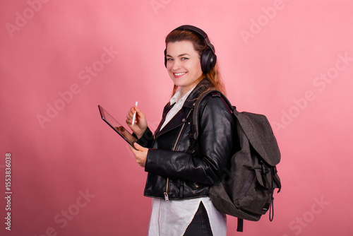 Woman with headphones, listening to music, fashion model in studio posing, music genre, smiling, rock, metal music , tablet