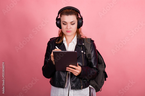 Woman with headphones, listening to music, fashion model in studio posing, music genre, smiling, rock, metal music , tablet