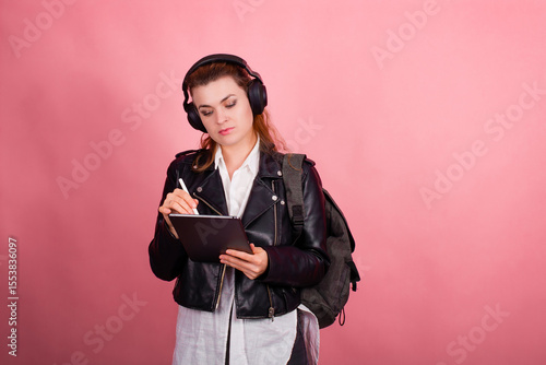 Woman with headphones, listening to music, fashion model in studio posing, music genre, smiling, rock, metal music , tablet