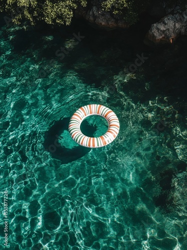 Lifesaver Ring Floating in Clear Swimming Pool Water on a Sunny Day.