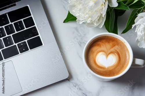 Warm Coffee Cup With Heart Design Beside Laptop and Flowers on Marble Surface