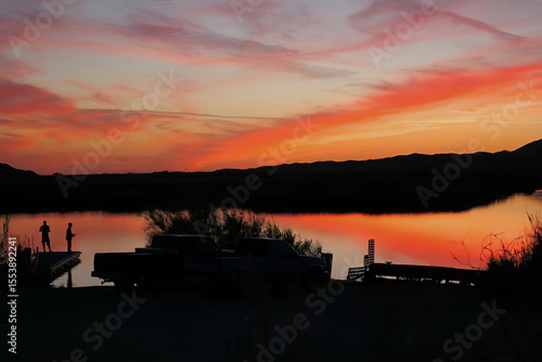 A panoramic view of two fishermen standing on a dock taken at sunset on Mittry Lake just North of Yuma, Arizona
