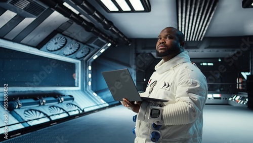 Tableau sur toile Astronaut in spacecraft using laptop to run telemetry data analysis