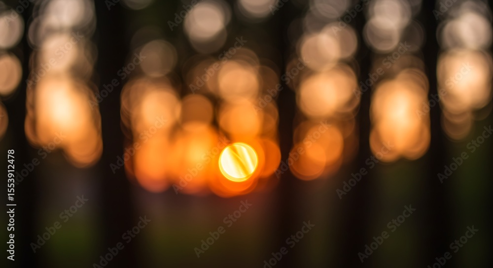 Obraz premium Warm Sunset Bokeh: Abstract Orange and Gold Light Through Trees, Peaceful Evening Mood, Nature Background
