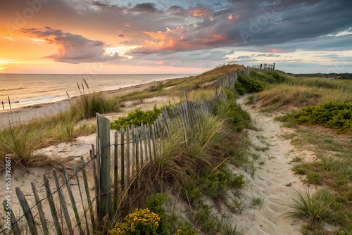 Scenic illustration showcases beach sand dunes by sea under dramatic sky. Old wooden fence, grass, weeds. Golden hour sunset, blue sea horizon. Nature, travel, vacation, and outdoor recreation