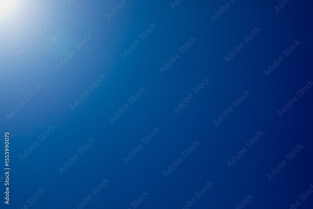 Blue abstract background. The sun hits the camera, and the blue sky becomes a gradient background. Blue abstract background. The sun hits the camera, and the blue sky becomes a gradient background.
