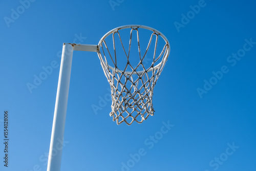 Принти на полотні Close-up view of a netball hoop and net against a clear blue sky