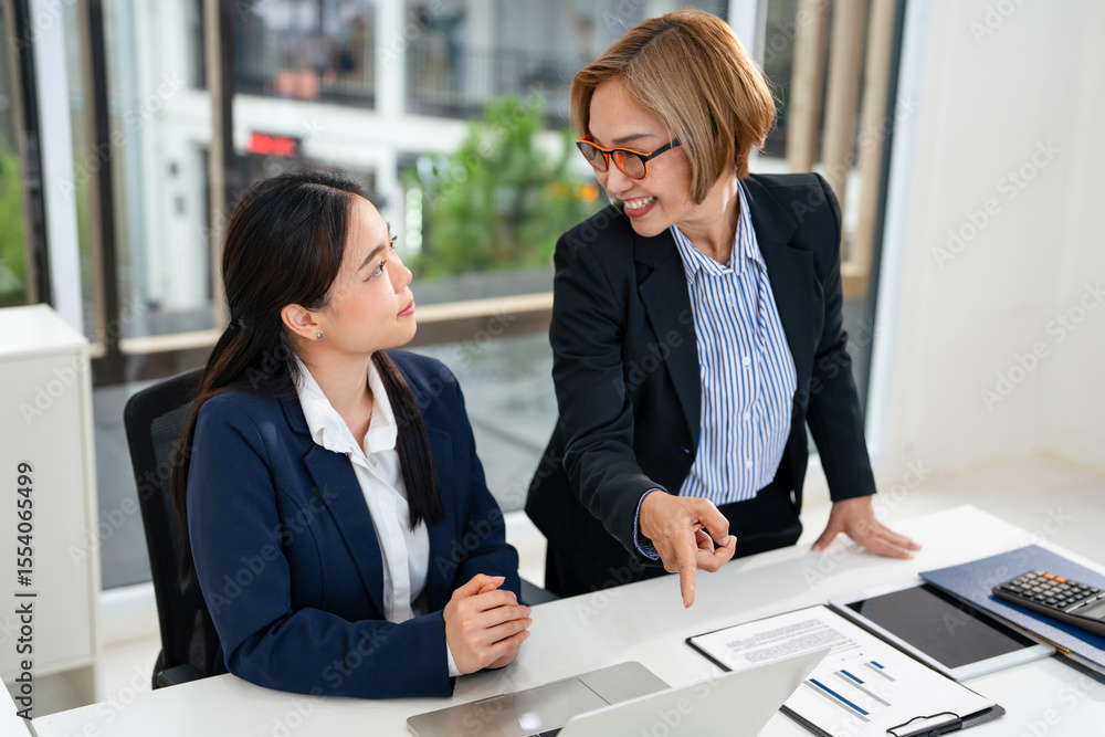 Φωτογραφία Two business women sit at desk discuss project details, diverse female colleagues met in office, share opinion, working on collaborative task, sales manager makes commercial offer to company client
