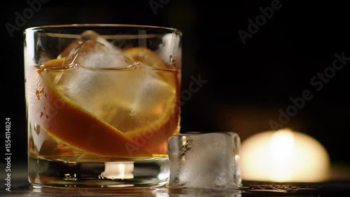 Whiskey Old Fashioned Cocktail: Ice, Orange Peel, and Dark Background