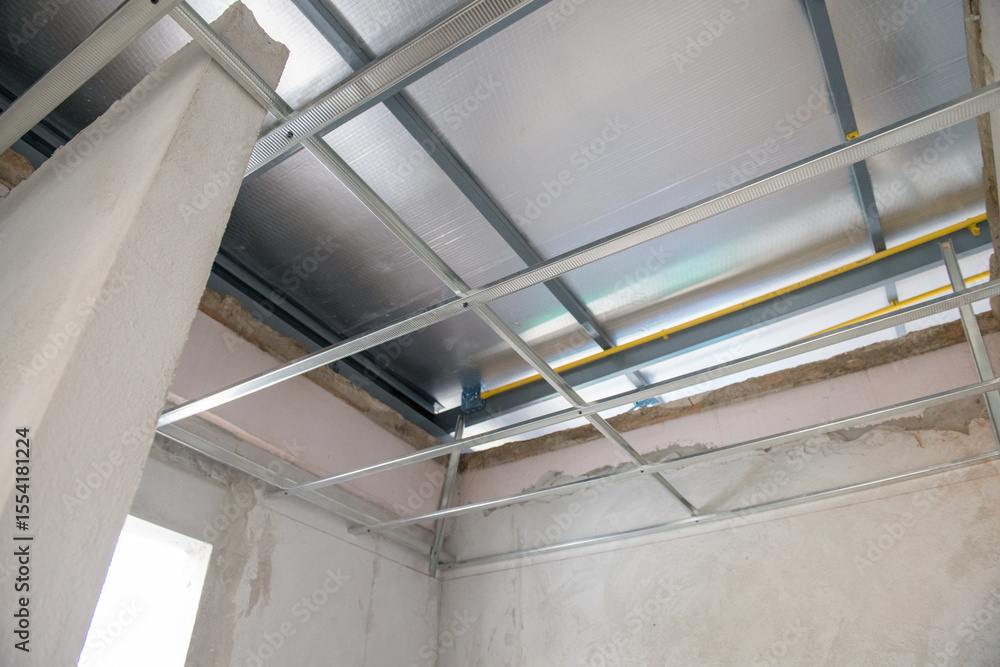 Obraz premium Interior renovation project showing aluminium ceiling framework and electrical wiring installation. new construction progress shows modern ceiling and room design