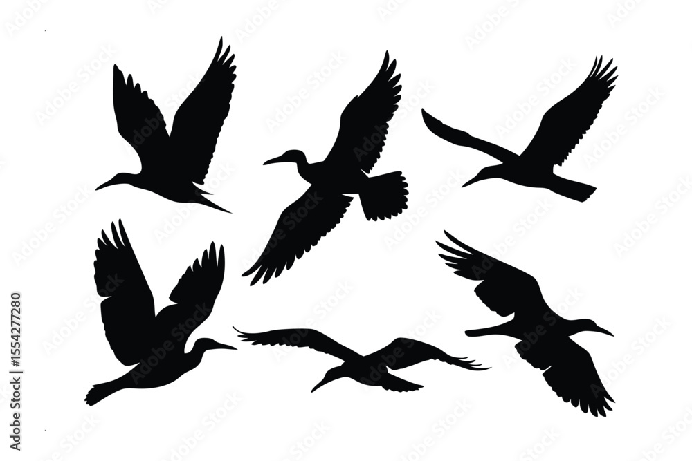 Fototapeta premium Soaring Silhouettes: The image features a collection of graceful black silhouettes of seabirds in flight, capturing their dynamic forms and free spirit.