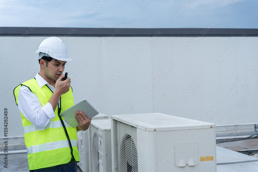 Asian maintenance engineer works on the roof of factory. contractor inspect compressor system and plans installation of air condition systems in construction. technology, online, mobile application. Asian maintenance engineer works on the roof of factory. contractor inspect compressor system and plans installation of air condition systems in construction. technology, online, mobile application.