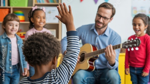 Male music teacher engages diverse children in classroom guitar lesson