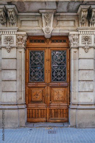 Photography Wooden Entrance Door Of A Classic Barcelona Building, Adorned With Stone Carvings