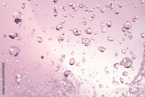 ピンクの背景に飛び散る水飛沫.