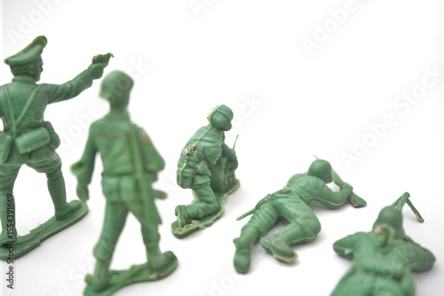 Green Plastic Toy Soldiers in Action on White Background, Macro Shot