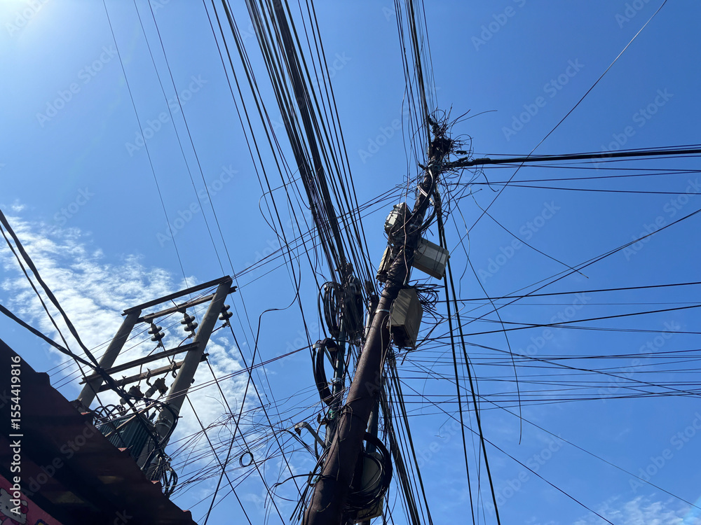Electrical Utility Pole with Numerous Wires and Equipment Against Bright Blue Sky Electrical Utility Pole with Numerous Wires and Equipment Against Bright Blue Sky