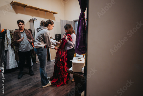 Papier peint Three young actors work together in a theaters backstage area, focusing on fitting costumes and preparing for their upcoming performance