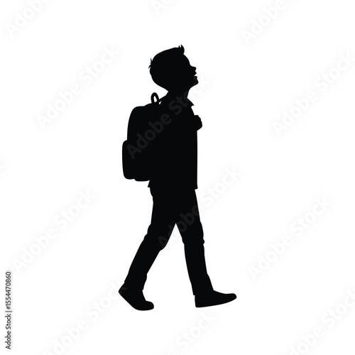 Silhouette of a schoolboy walking with a backpack looking up
