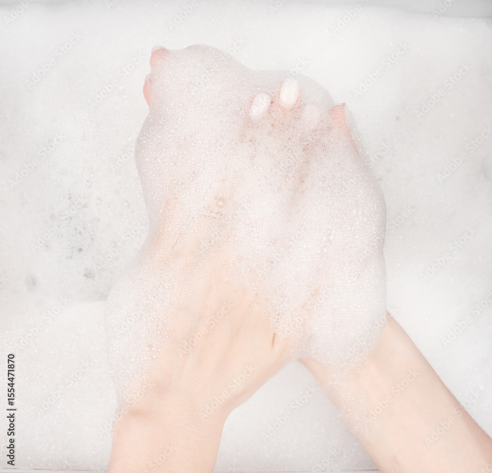 Fototapeta premium Female hands in foam close-up. girl's hands in soap foam. washing, cleaning, washing dishes