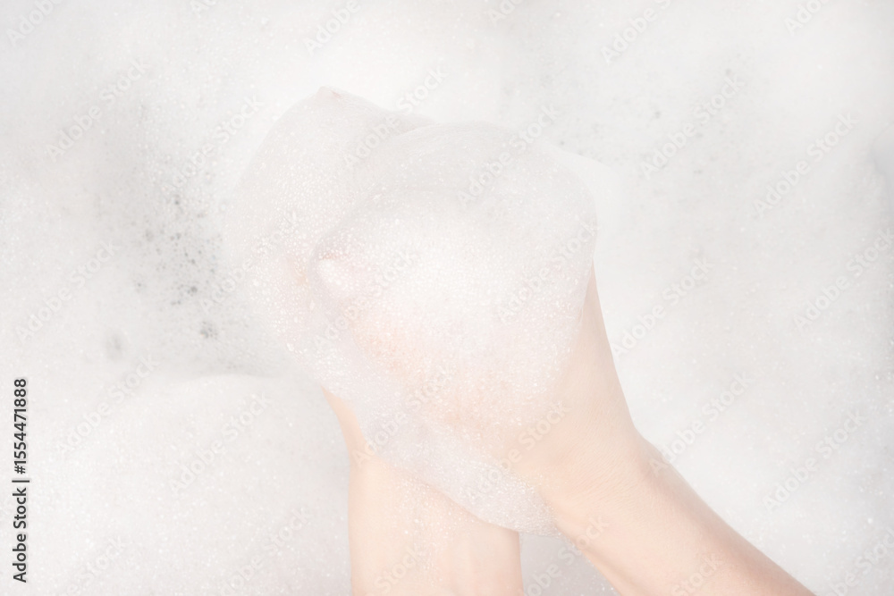 Fototapeta premium Female hands in foam close-up. girl's hands in soap foam. washing, cleaning, washing dishes