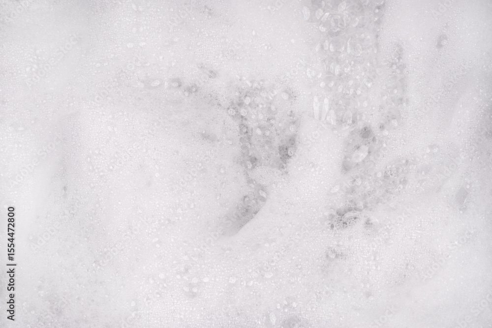 Fototapeta premium White pure foam in water background texture. dishwashing foam close up