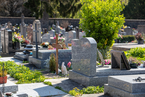 Un cimetière communale en France avec un groupement de sépultures et de tombes. Espace funéraire du souvenir signalé par un monument, des symboles ou des inscriptions  et des fleurs.