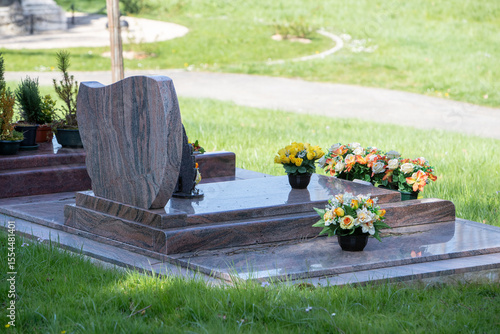 Le fleurissement d’une tombe avec un bouquet de fleurs orange. Cela permet de rendre hommage au défunt et de témoigner son attachement et le respect envers cet être cher. 