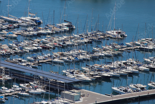 Moored Yachts and Sailboats in Alicante Marina with Solar Roof Dock and Calm Blue Waters on a Bright Summer Day in the Mediterranean