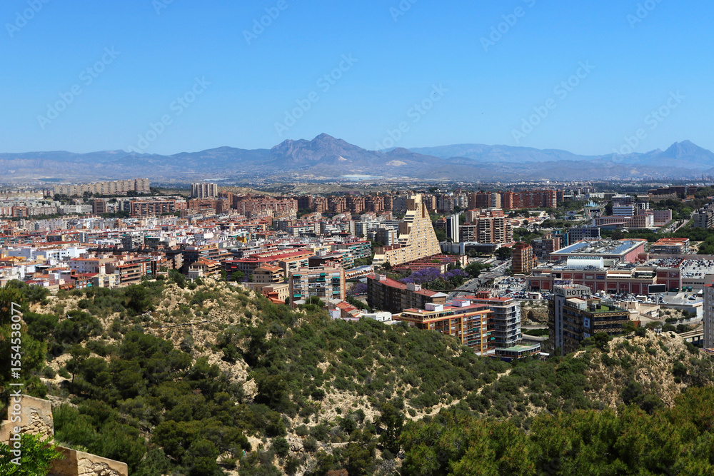 Obraz premium Panoramic View of Alicante Urban Landscape with Unique Architecture and Mountain Range in the Background under Clear Blue Sky