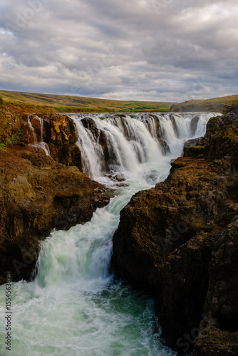 Majestic waterfalls cascading through Kolugljufur Canyon in Iceland during golden hour