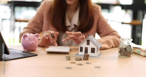 Hand plans home refinance. Pressing calculators, House model, buy or rent, calculators on desk. Saving for property purchase, optimal mortgage payment. Tax, credit analysis for financial planning.
