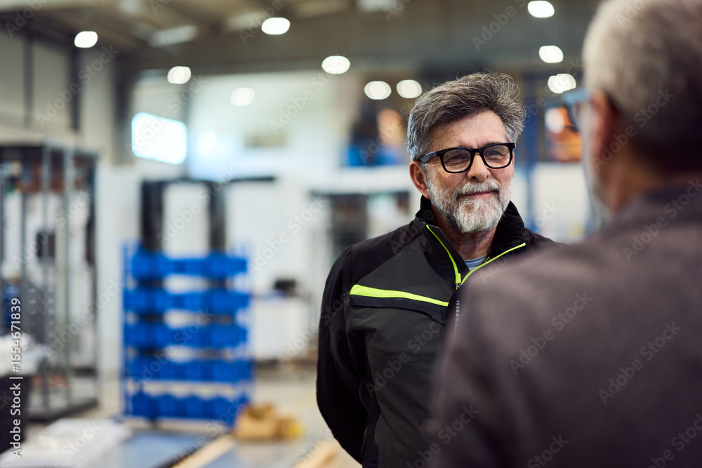Fototapeta premium Two Professionals Engaging in Conversation in an Industrial Setting