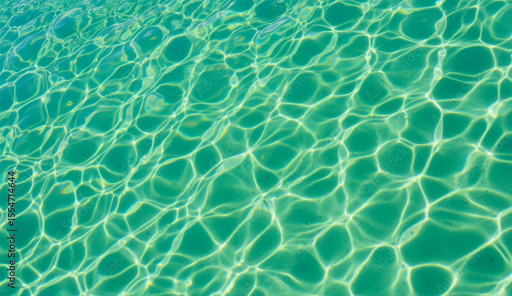 Obraz premium Clear Turquoise Swimming Pool Water Surface with Sunlight Reflection Patterns
