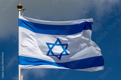 Large Israel flag waving in the wind. Israeli flag for advertising, holidays, achievements, festivals, elections. The Israeli flag flutters in the beautiful sky. Great for news.