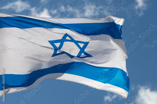Large Israel flag waving in the wind. Israeli flag for advertising, holidays, achievements, festivals, elections. The Israeli flag flutters in the beautiful sky. Great for news.