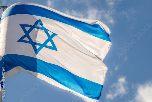 Large Israel flag waving in the wind. Israeli flag for advertising, holidays, achievements, festivals, elections. The Israeli flag flutters in the beautiful sky. Great for news.
