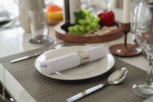 Fotografia Elegant dining table setting with refined tableware, neatly arranged napkin, win