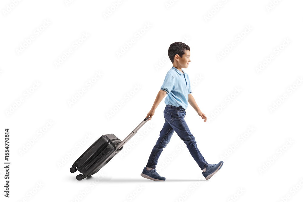 Full length profile shot of a boy walking and pulling a suitcase Full length profile shot of a boy walking and pulling a suitcase