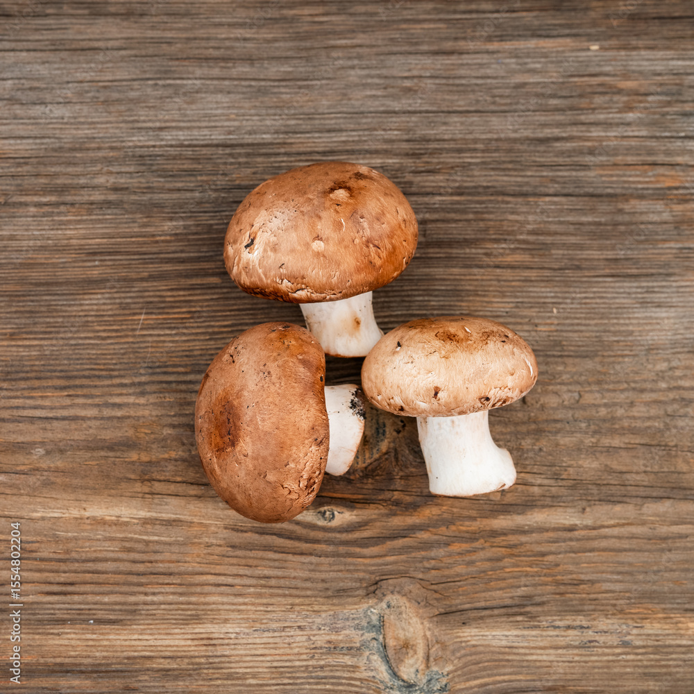 Pile of delicious champignon mushrooms on wooden background Pile of delicious champignon mushrooms on wooden background