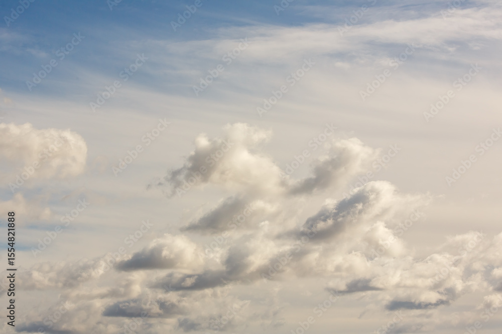 Fototapeta premium Dramatic sky filled with layered cumulus and stratus clouds, showing movement and depth under soft natural daylight.