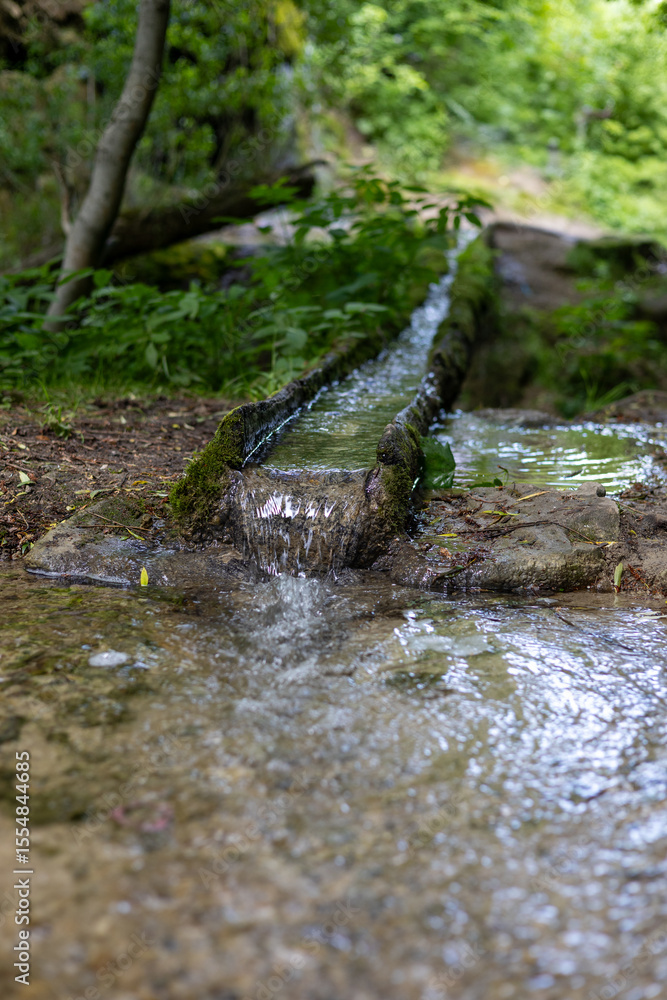 Fototapeta premium Water flows through a thin gutter