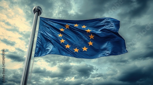 Fototapeta Naklejka Na Ścianę i Meble -  EU flag waves, yellow stars, against ominous cloudy sky