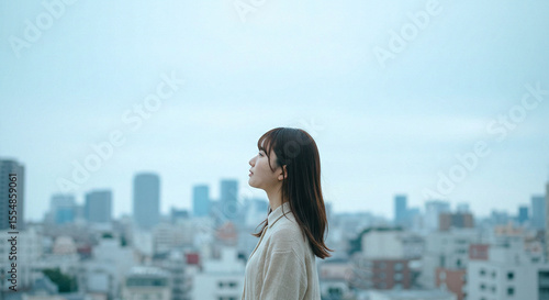 都会の空を見上げる日本人女性