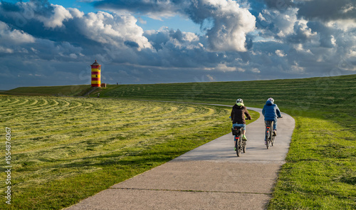 Radfahrer auf dem Weg zum Pilsumer Leuchtturm in Ostfriesland, Deutschland