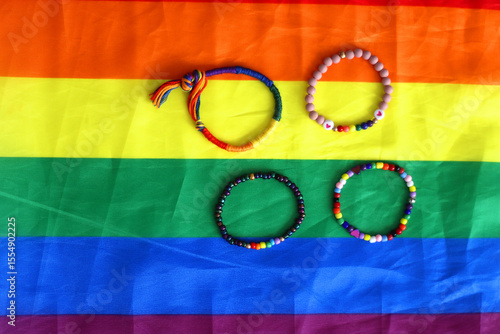 Rainbow friendship bracelets and pride flag. Pride month concept, top view.