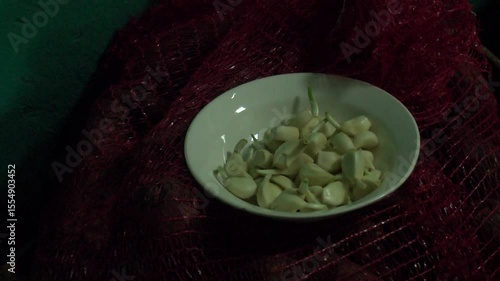 Woman peeling garlic preparation for cooking in the kitchen