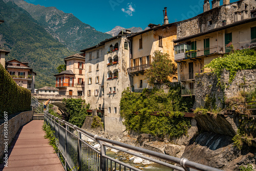 Fototapeta Naklejka Na Ścianę i Meble -  Historic Town of Chiavenna with Colorful Riverside Buildings and Stone Bridges: Scenic Italian Village Nestled Among Green Mountains and Flowing River