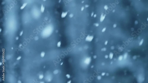 Falling snow flakes create a blurry winter background