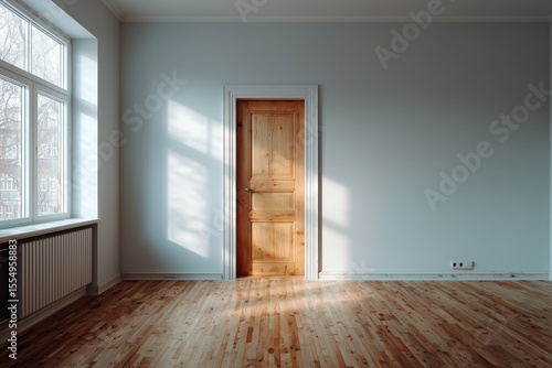 Warm sunlight streams into an empty room with a wooden door, showcasing natural textures and a serene atmosphere.